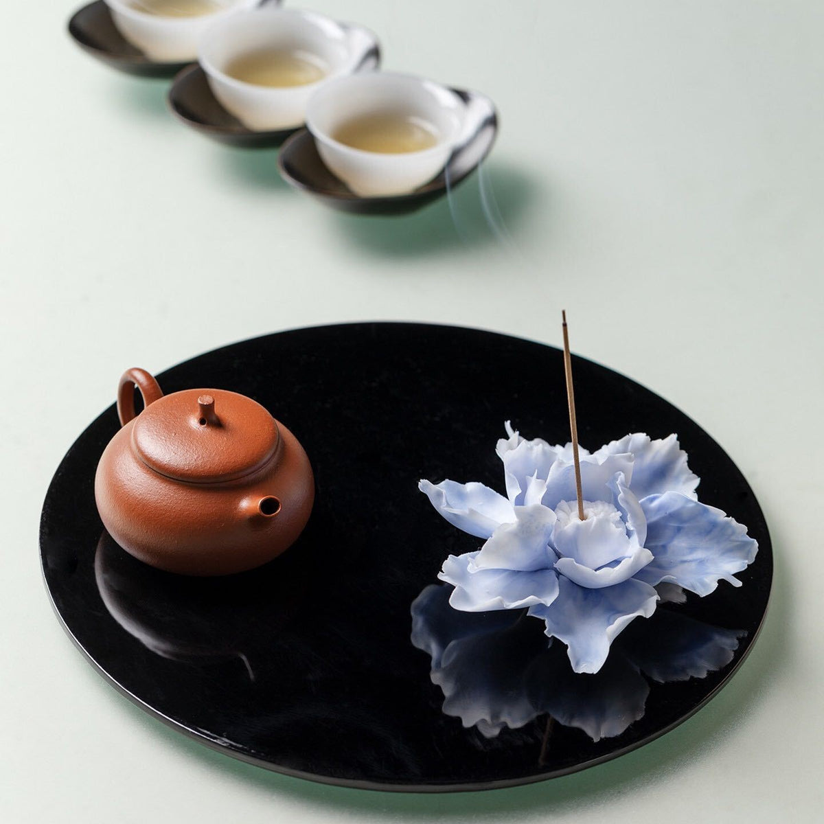Artisan pressing the edge of a porcelain clay petal before attaching it to a flower. Use a genuine process image of that action.