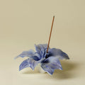 Blue ceramic lily incense holder with an upright incense stick