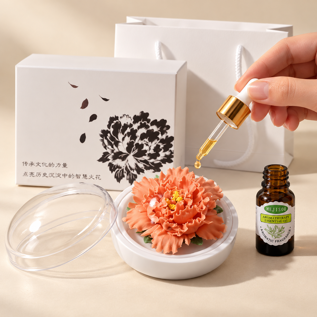 Orange ceramic peony flower and oil gift set, compact version — oil being dropped onto the ceramic flower petals