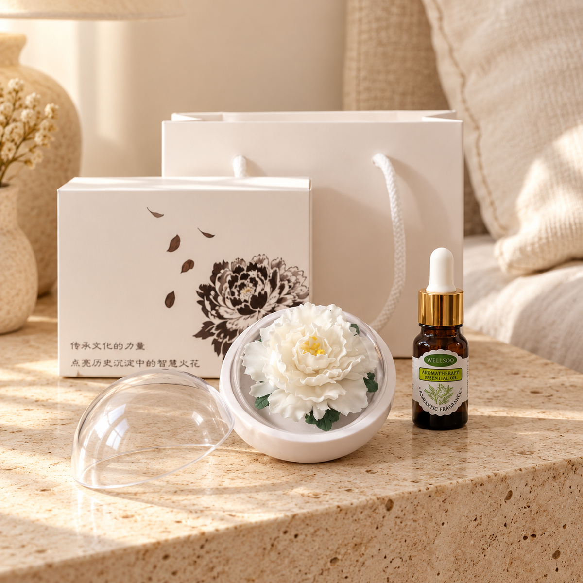 White ceramic peony flower and oil gift set, small version — gift set styled on a bedside table in a beige room